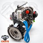 Cummins 6BT complete excavator engine, rear view showing flywheel, turbocharger and blue hoses.